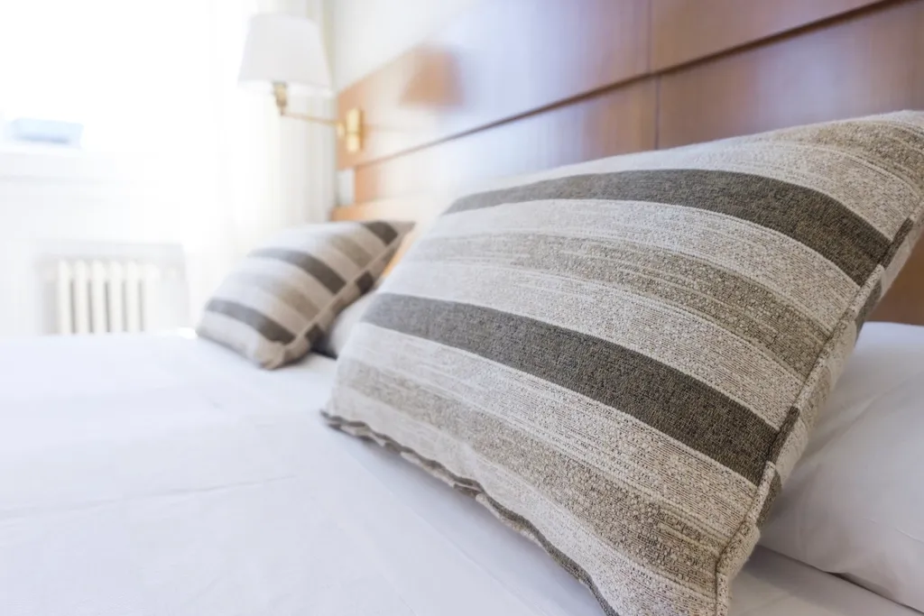 Natural striped cushions resting against a wooden headboard