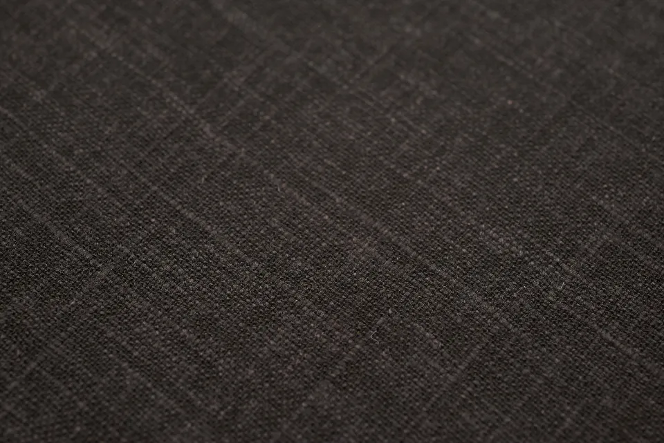 Close view of the loose weave and folded edge of brown linen