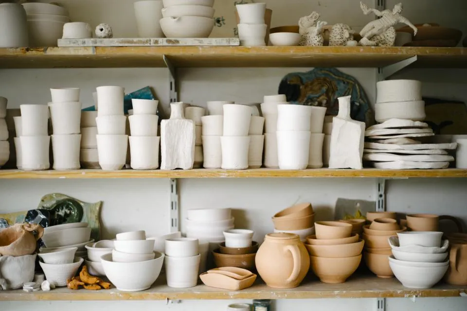 Shelves filled with cream and terracotta cups, bowls and pitchers