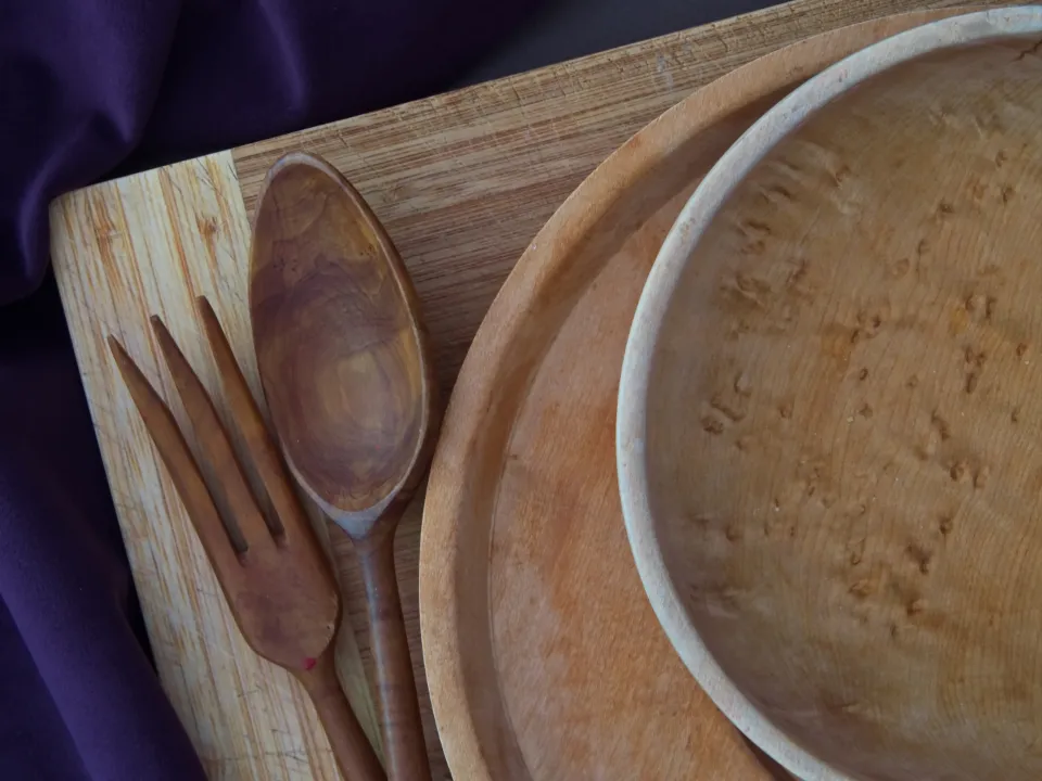Nested wooden bowls and serving spoons with a warm, visible grain